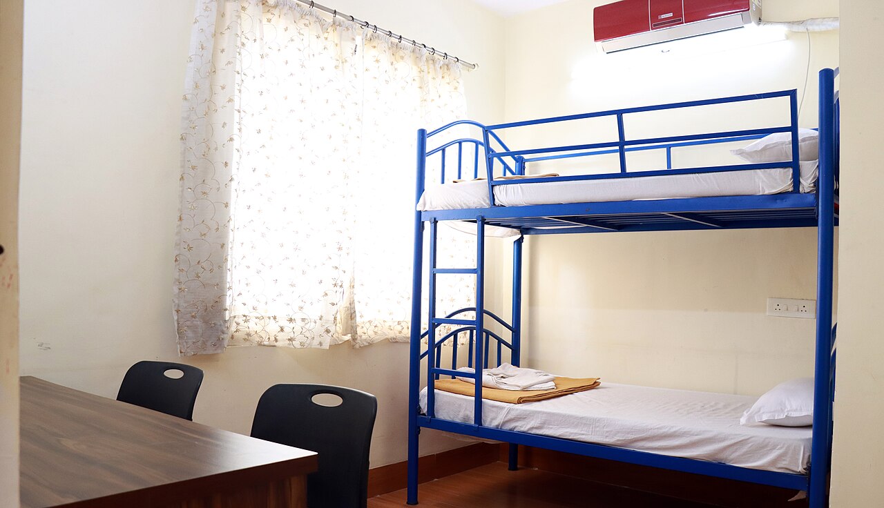 Furnished hostel room with study table and bunk bed